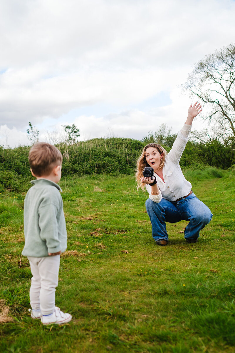 Photographer pulls funny face at toddler