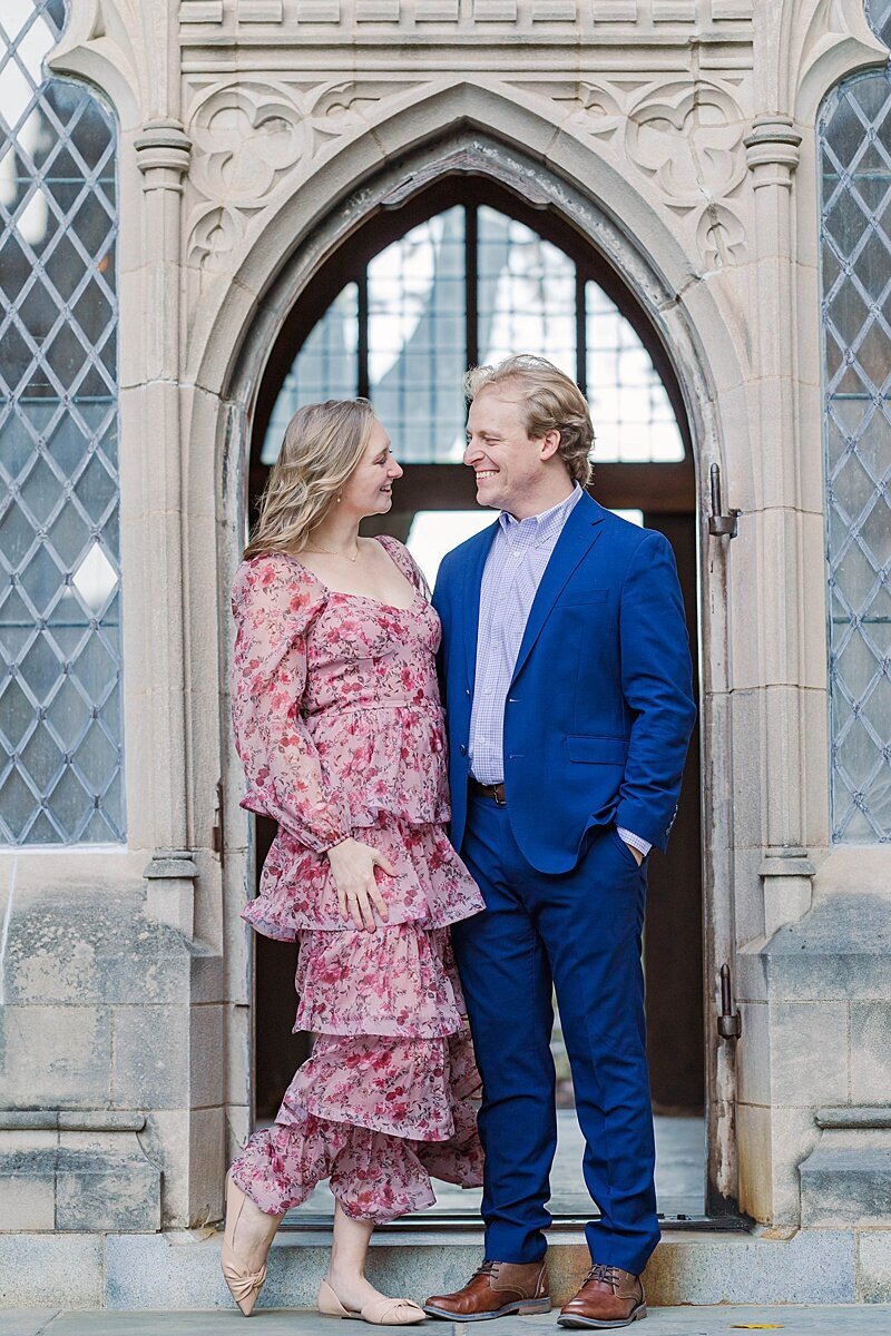 Washington DC engagement session at the National Cathedral with couple posing by gothic arches and landscaped grounds during golden hour