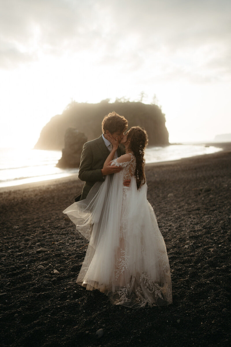 A couple kissing on Ruby Beach at sunset during their Olympic National Park elopement.