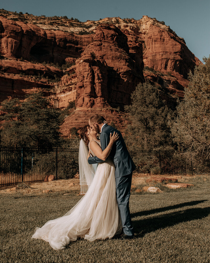 first kiss at intimate wedding with red rocks at enchantment resort in sedona arizona