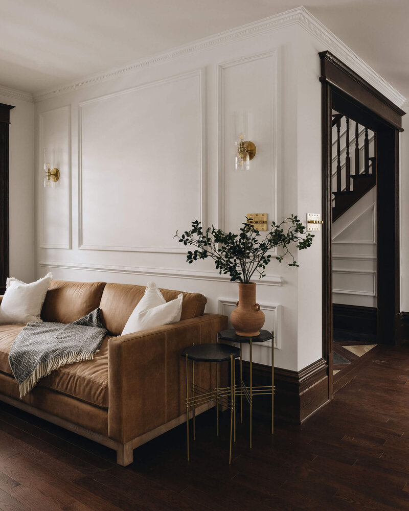 Modern Montreal designed entryway with leather couch and wood moldings