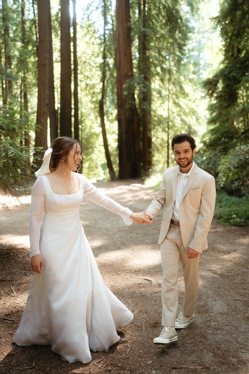 Bride and groom laugh during their Henry Cowell State Park Wedding as they walk through a beautiful forest