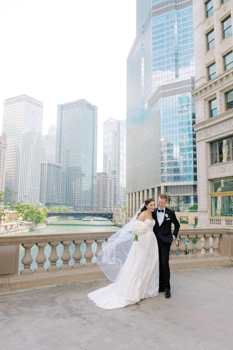 Couple laughs together while embracing on the bridge near the Wrigley Building in downtown Chicago