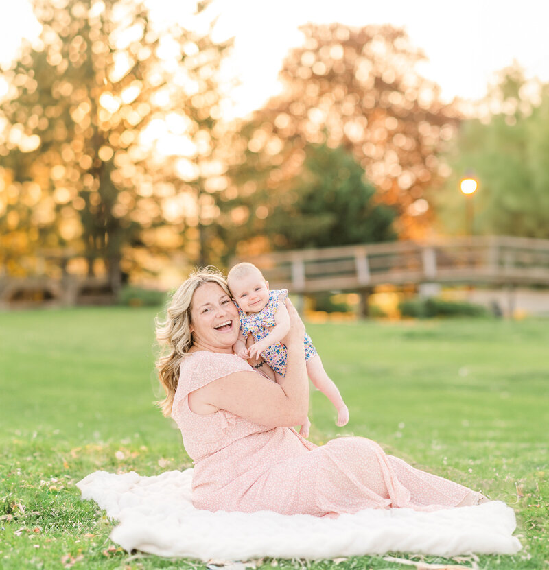mother nursing her baby girl in their yard next to their yellow rose bush by york pa photographer