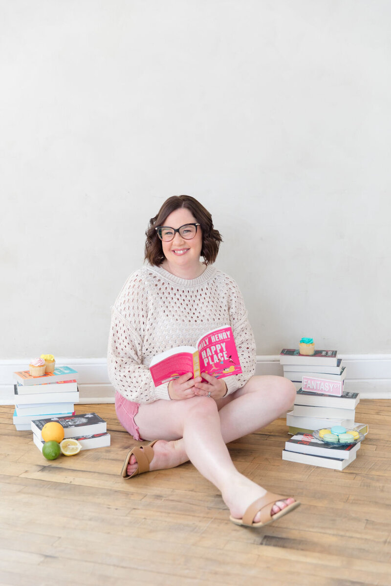 Bookseller Sara Gillis sitting on the floor surrounded by books