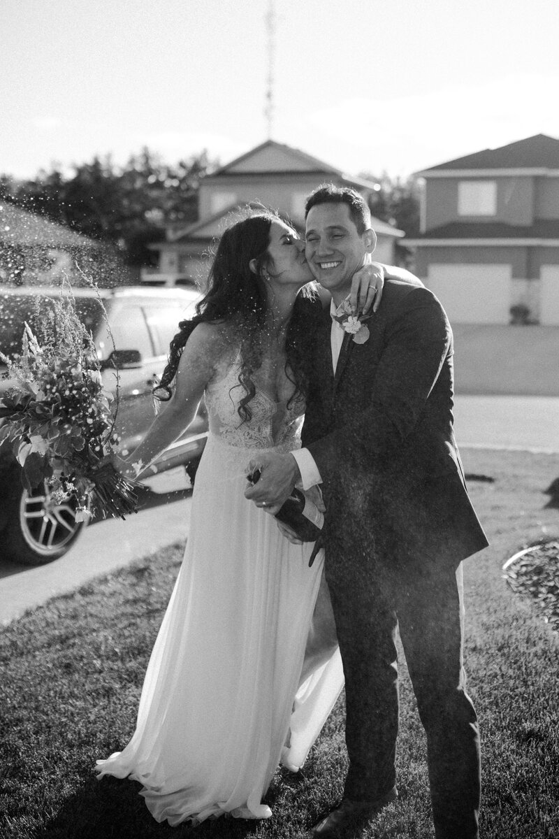 bride and groom popping champagne