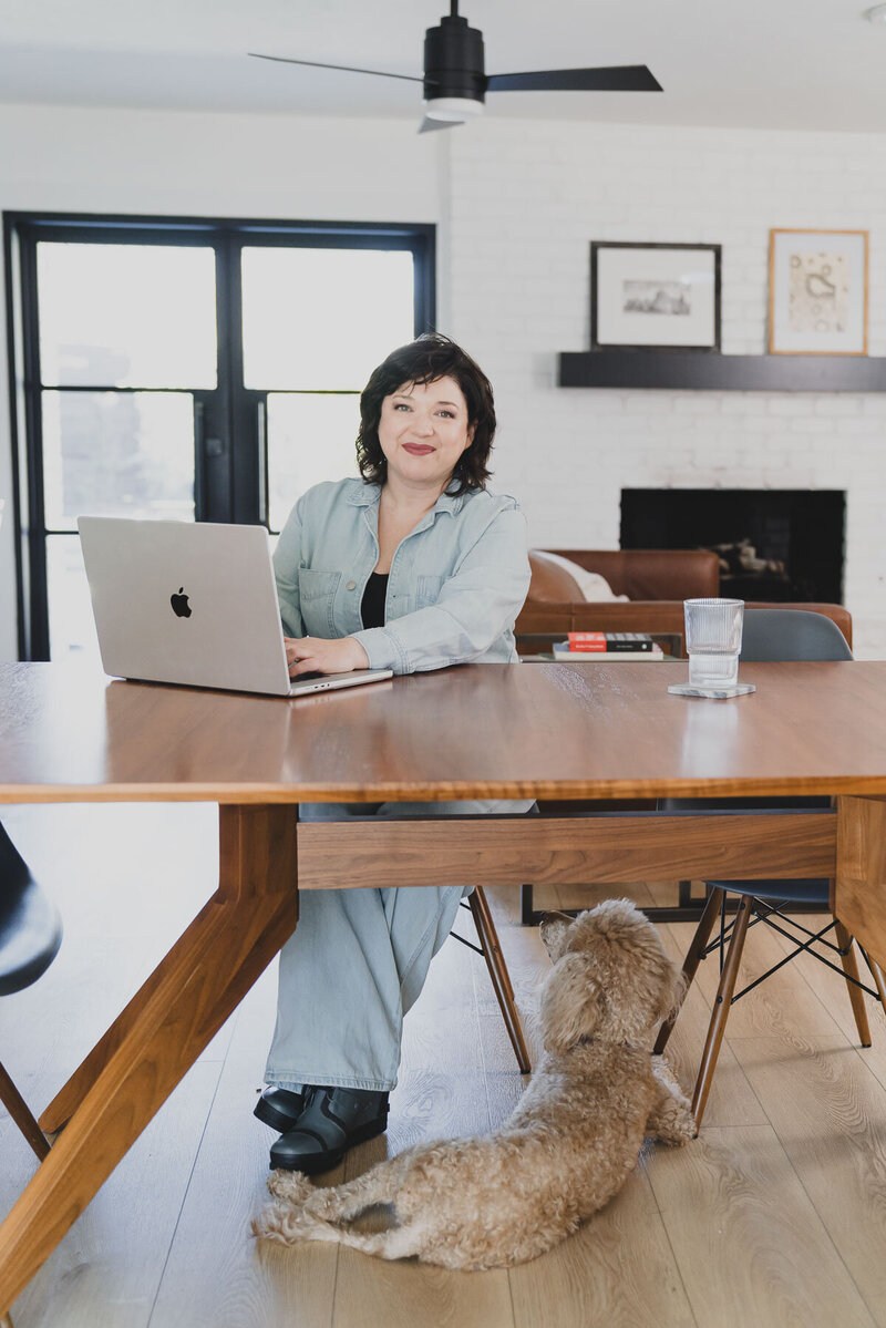 Desiree Peterson sitting on her office while on  her laptop .