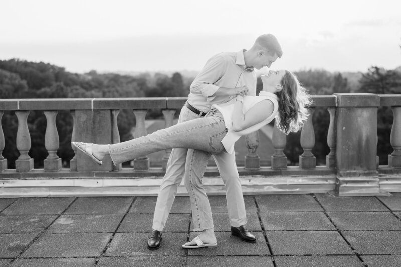 A young man dips his fiance on top of the observatory at Ault Park