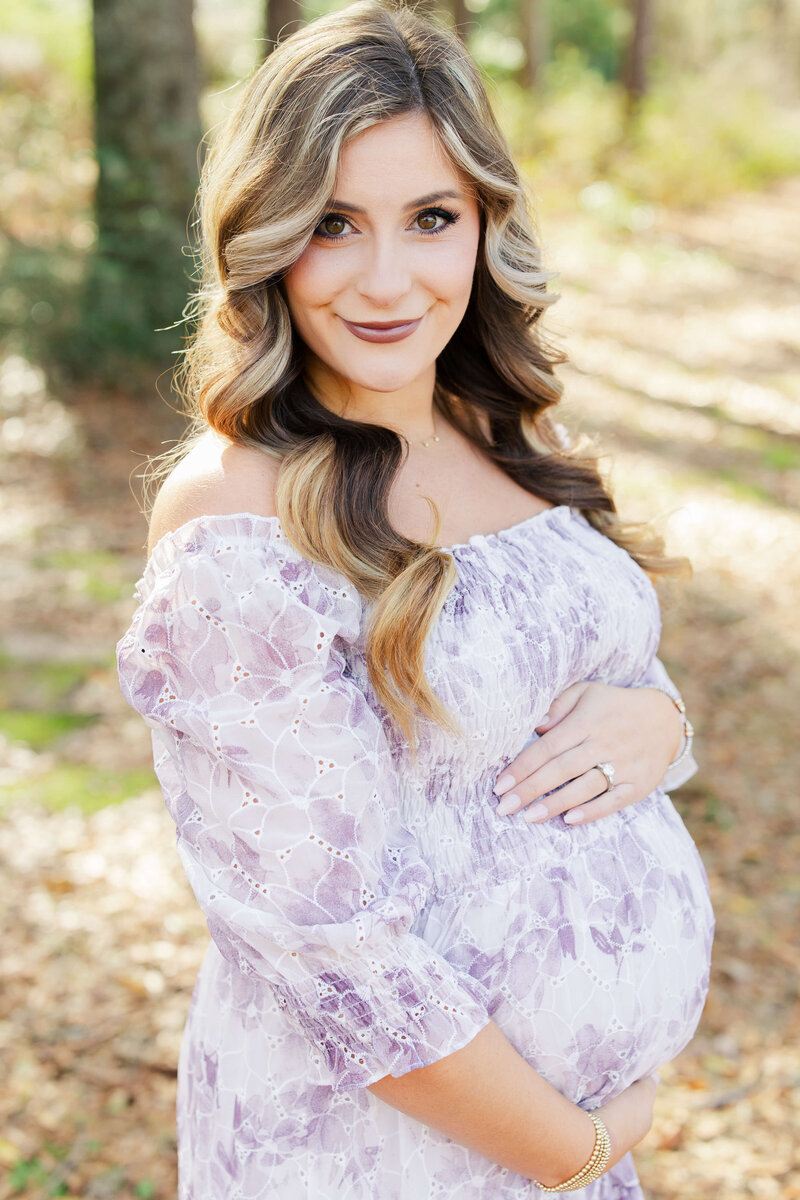 Woman standing holding pregnant belly in Dothan Alabama Park for Maternity Photography session