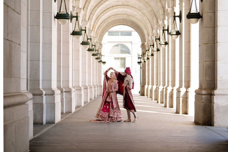 Fiaz spins his wife, Shahira as the light of the union station tunnel in washington dc drape envelop them amongst the colums