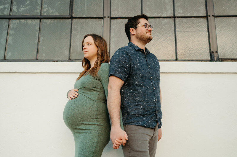 maternity couple standing in a field