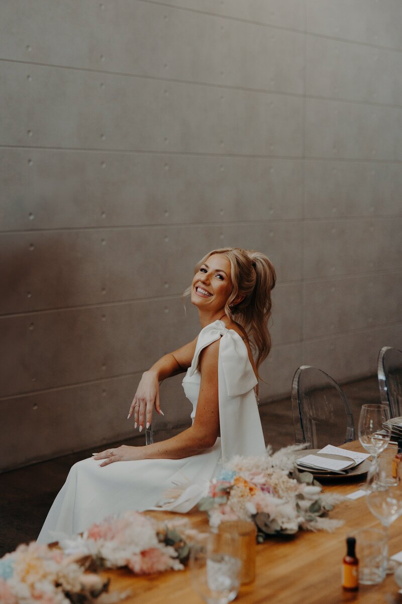 Brisbane bride seated with a beautiful high ponytail  and pink, blushy toned makeup