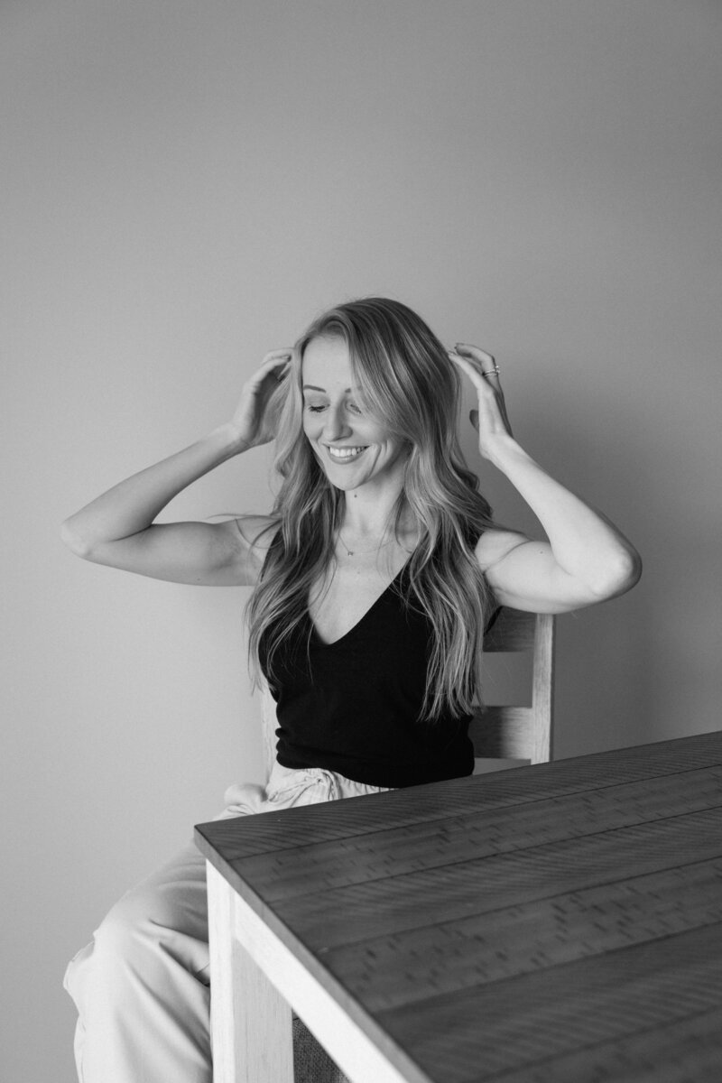 black and white photo of a girl laughing at the table