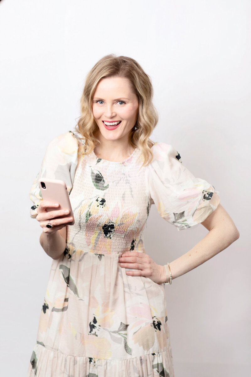 Lady holding a mobile phone  posed with hand on hip