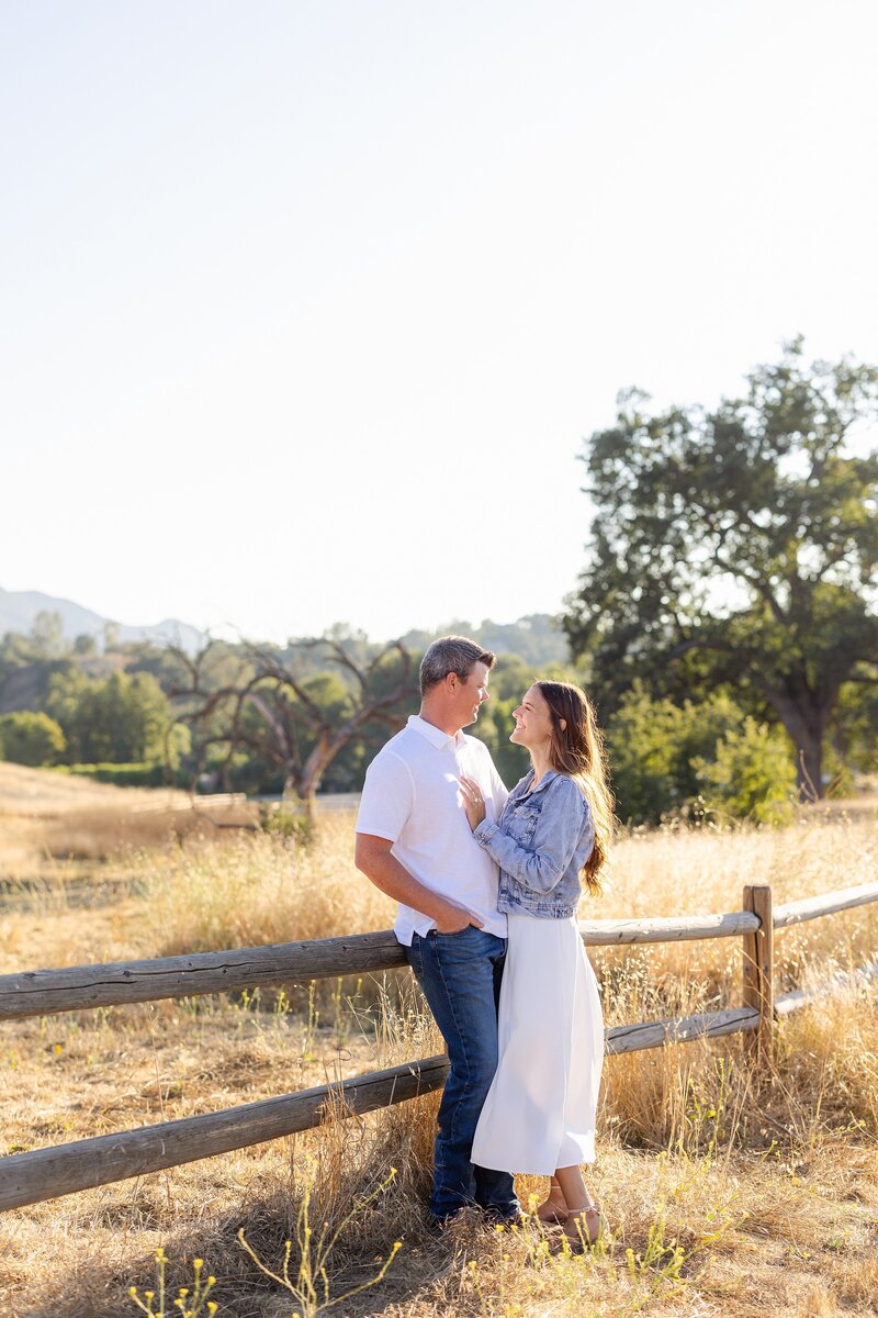 couple by rustic fence for Agoura Hills engagement photos