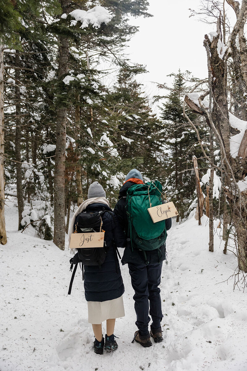 A couple hiking in the snow after eloping