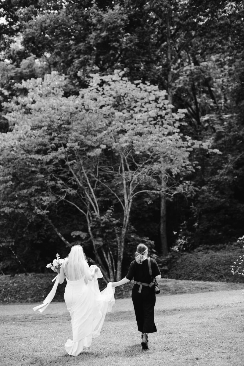 Maddie Moore helping a bride with her dress on her wedding day in Chattanooga, TN