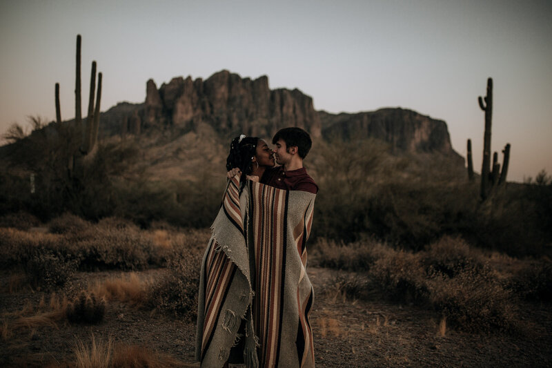 couple at sunset at superstition mountains in blanket with braids