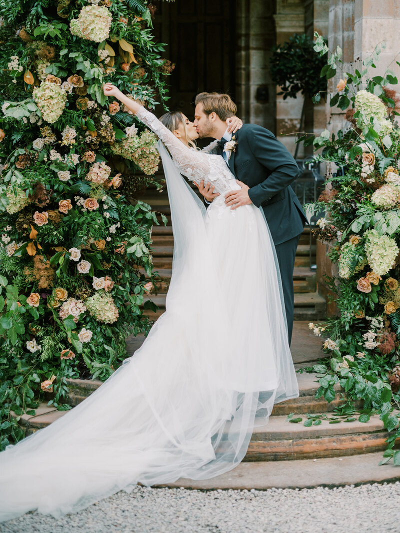bride-and-groom-in-front-of-flower-arch