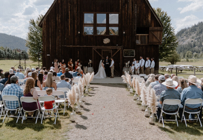 bride and groom standing at the alter with all their guests seated