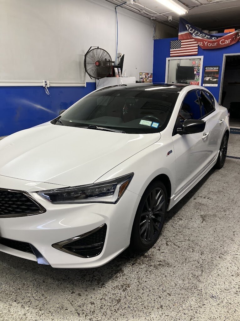 White luxury car receiving expert detailing services at Superstar Auto Spa. This image showcases our commitment to premium car care, including exterior cleaning and paint correction for high-end vehicles.
