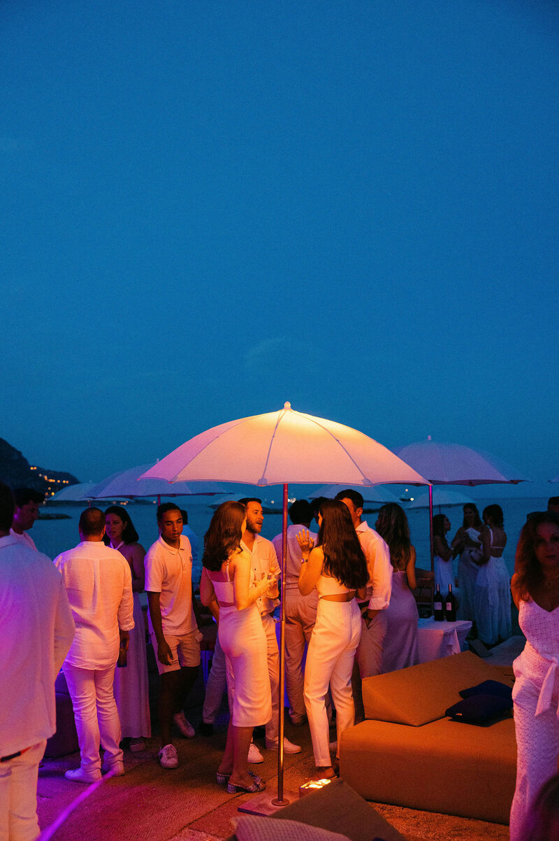 Night shot of multiple guests chatting under the moonlight in Cap Ferrat.