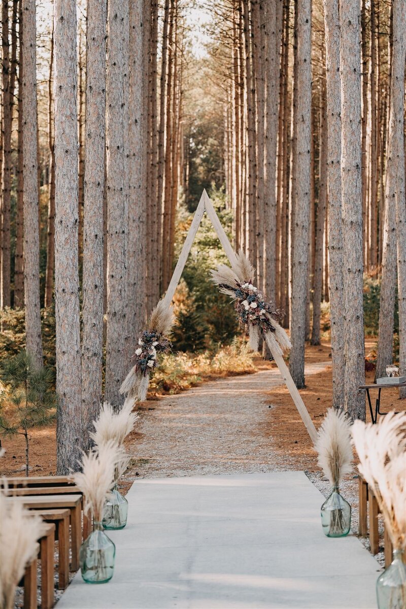 Stunning triangular ceremony arch with wedding flowers