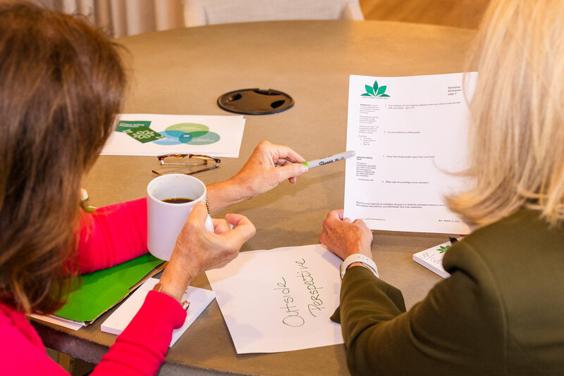 woman explaining a business detail to a client in a meeting room during brand photo shoot Atlanta with Laure Photography