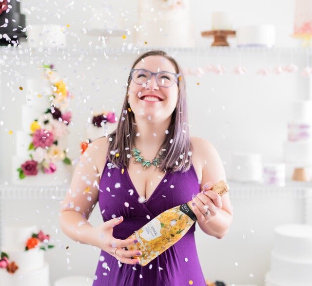 woman holding a champagne bottle with confetti falling down