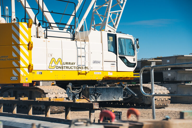 Murray Constructions crane in action on-site, showcasing industrial capability and brand identity.