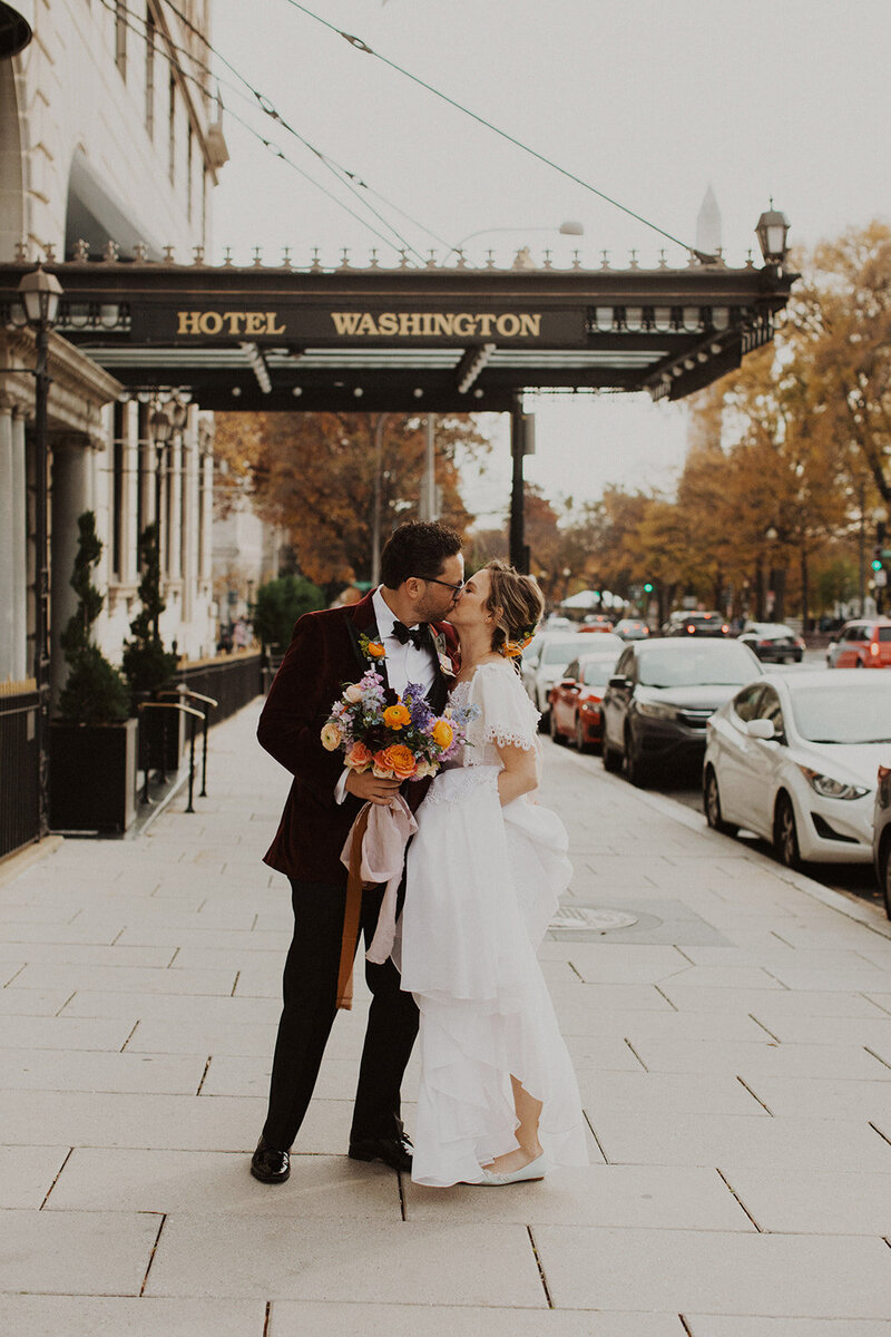 Bride and Groom Kiss in front of Hotel Washington in Washington DC Wedding