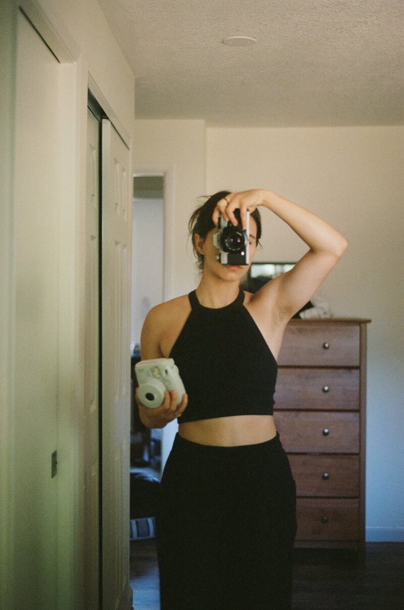 Photographer taking mirror selfie with vintage film camera