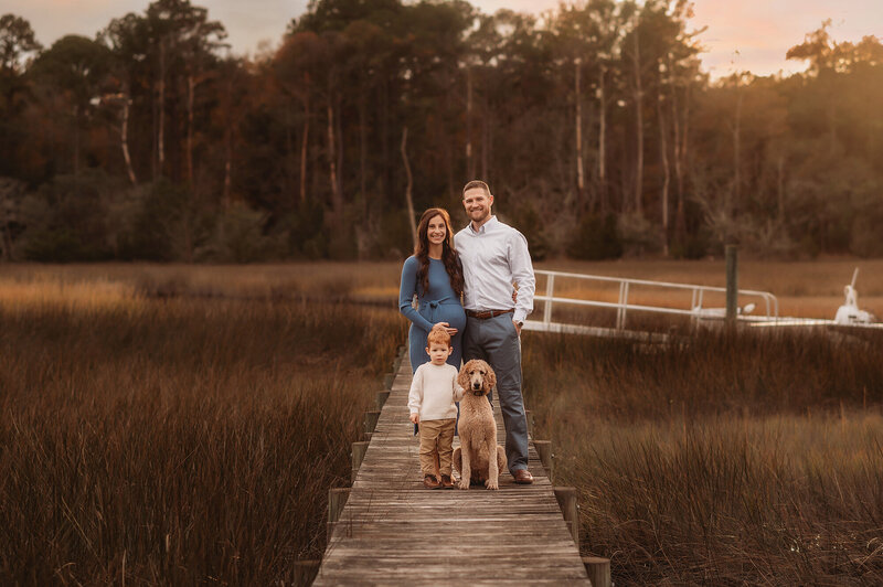 Family poses together during Maternity Photoshoot in Charleston, SC.