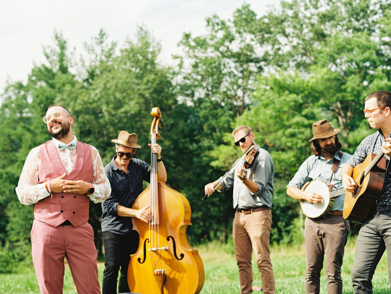 A bluegrass band plays and sings for the wedding ceremony, captured on film by destination photographer My Sun and Stars Co.
