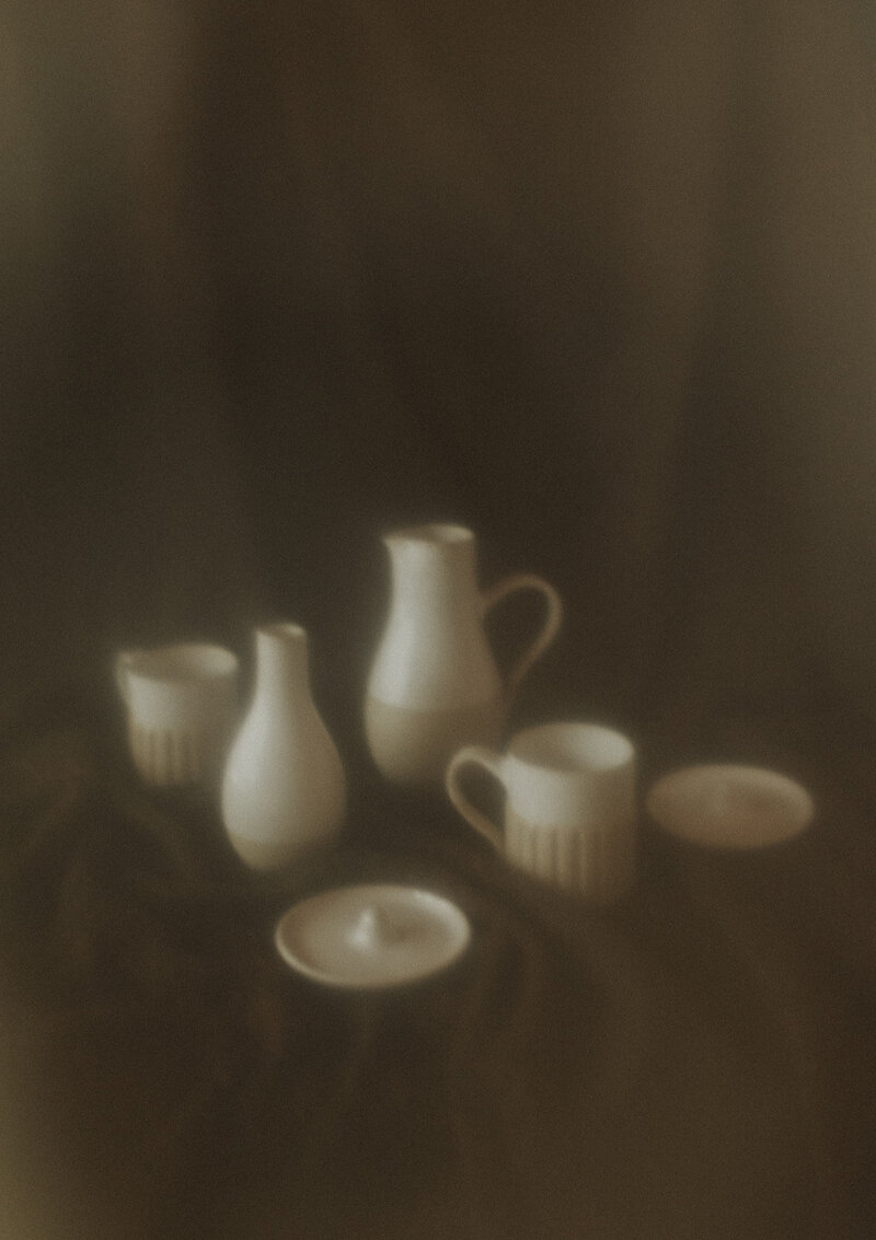 A product photo of handmade pottery items. Brown background.