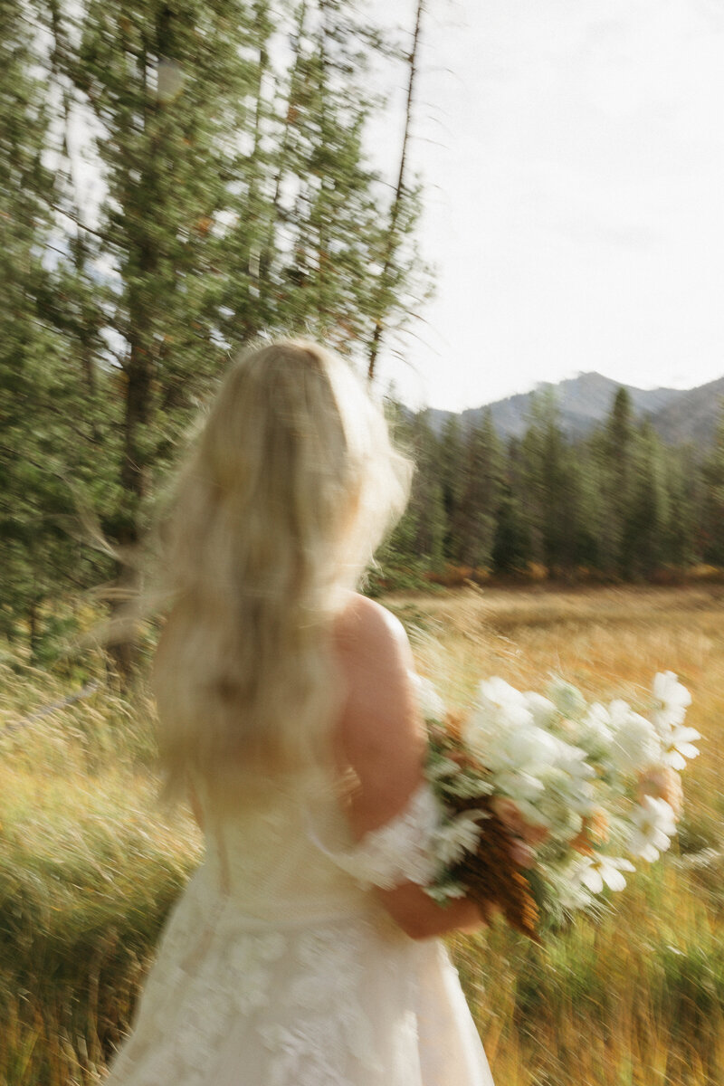 Bride holding bouquet in field
