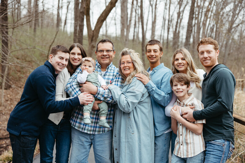 Candid extended family photo of everyone hugging and smiling at the camera in a park setting in St. Louis, Missouri. 