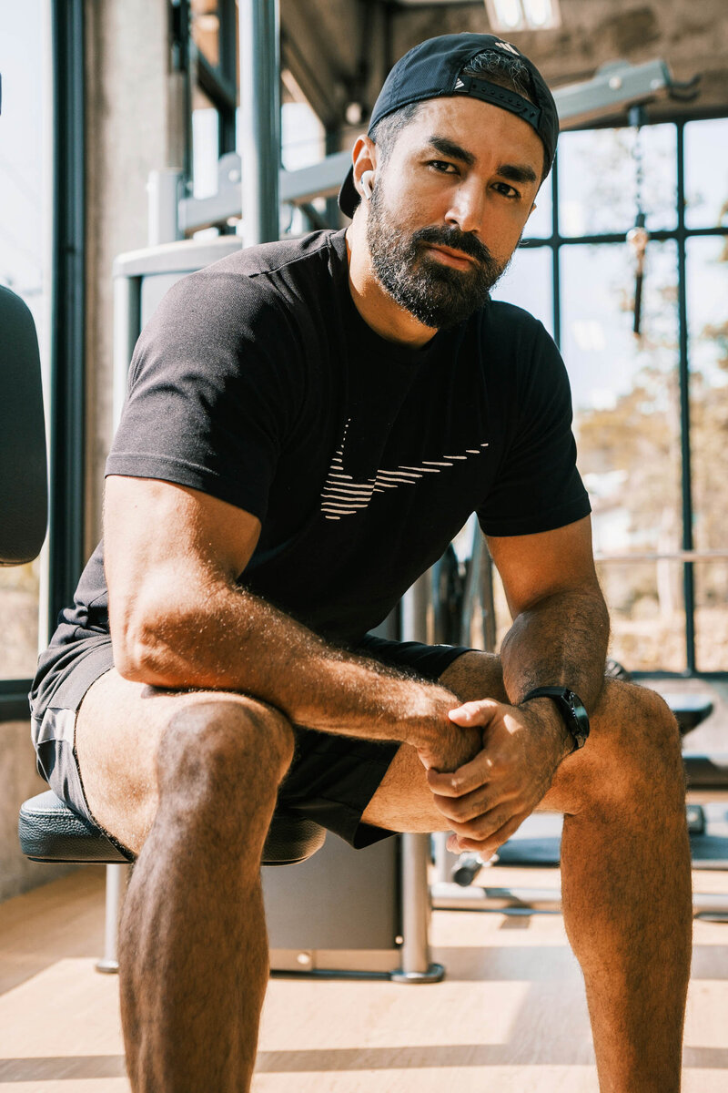 Fit man sitting on a workout bench.