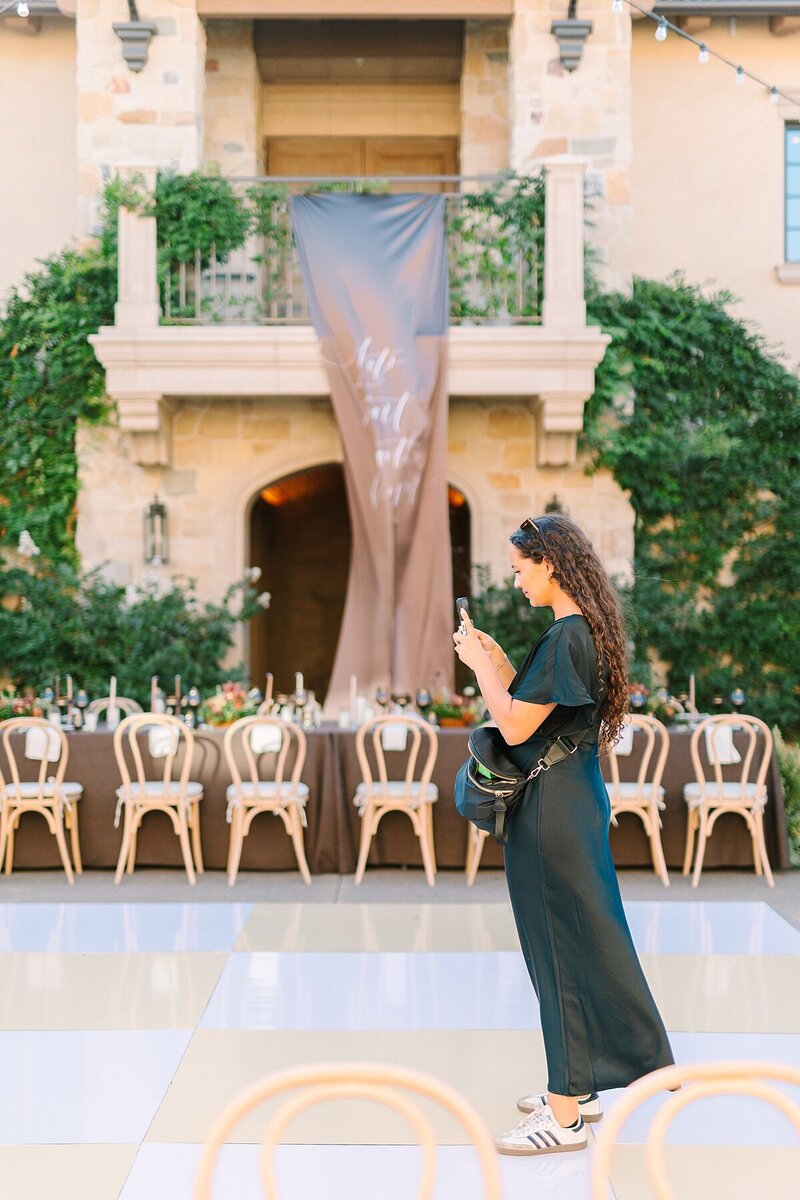 Lead wedding and event content creator, Makana Arvizu, holding up her gimble and phone to record content in Encinitas, California.
