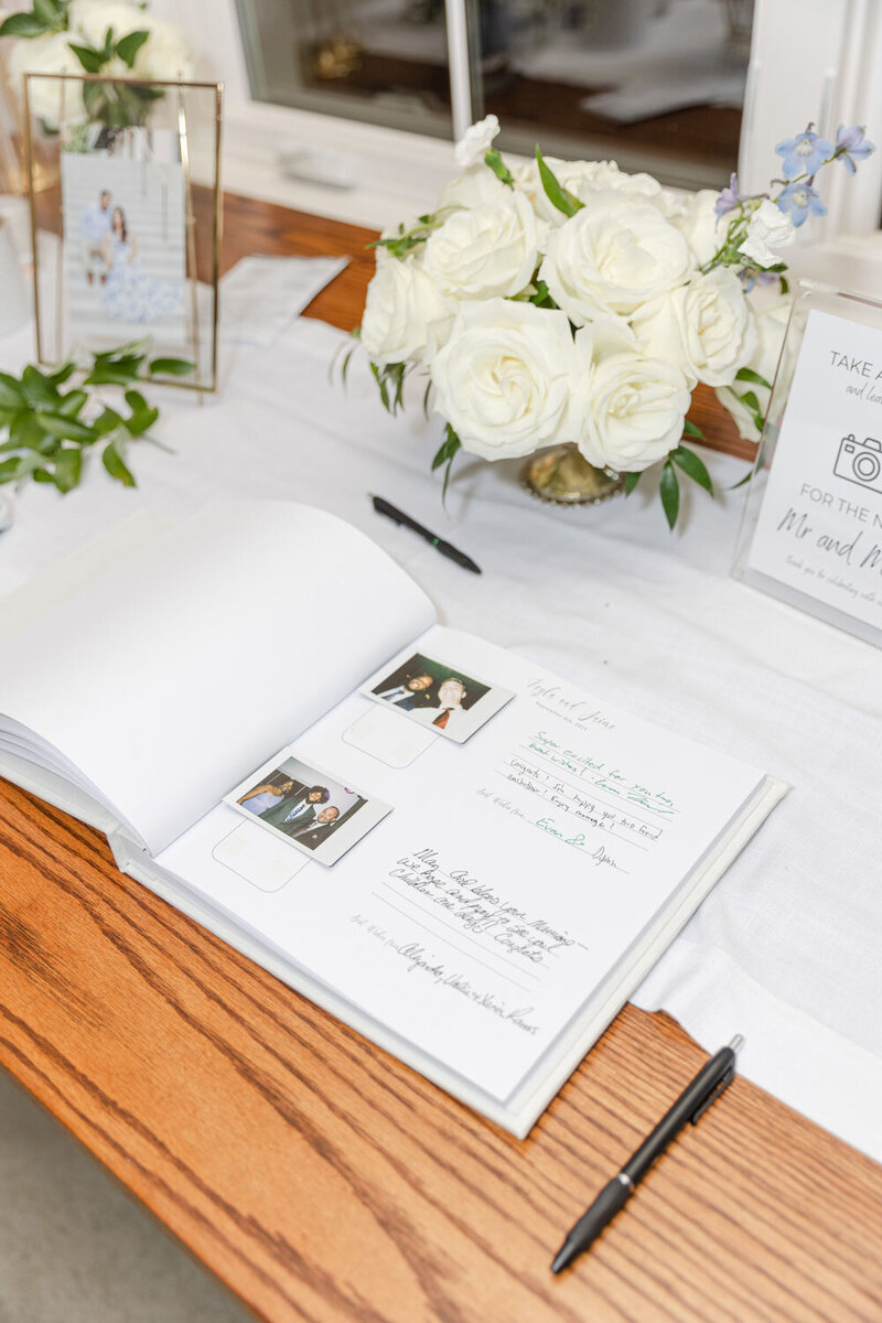 Wedding guest book with Polaroid photos and white roses