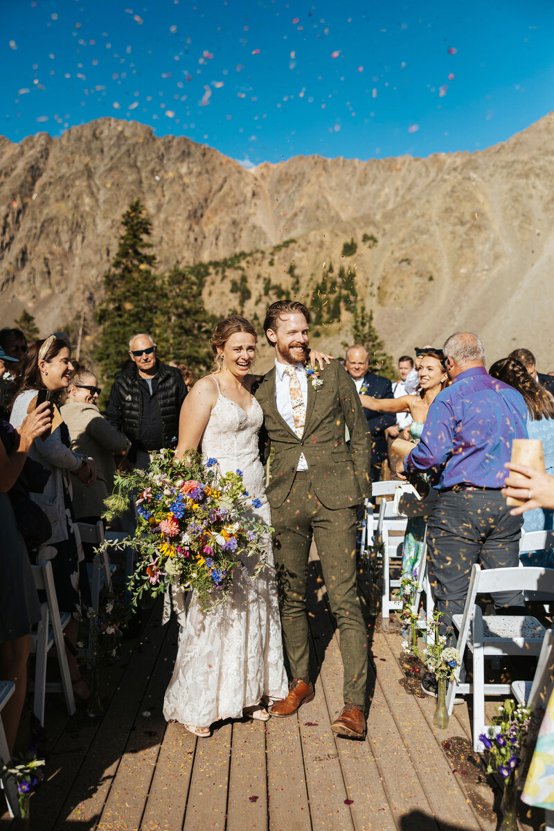 A wedding couple dancing in front of a motorcycle.
