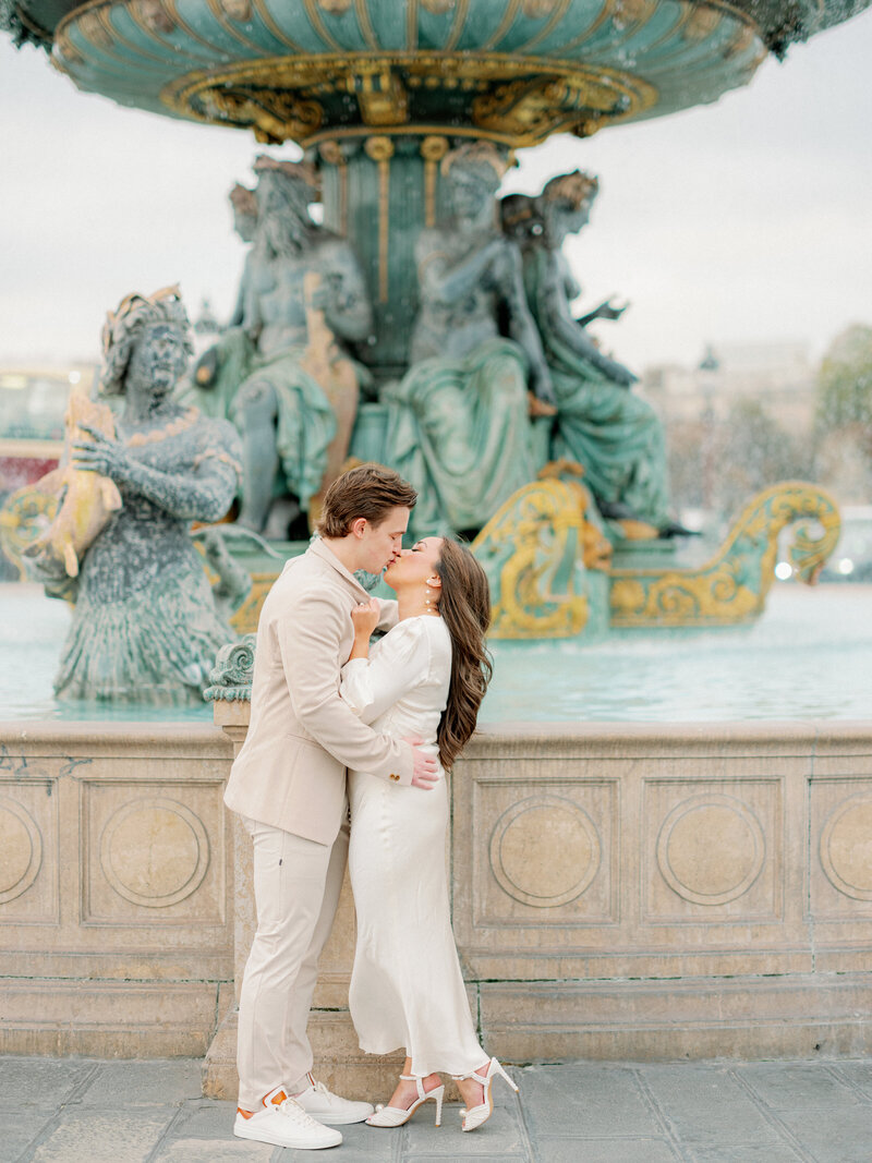 A couple kissing in front of the concord fountain in Paris