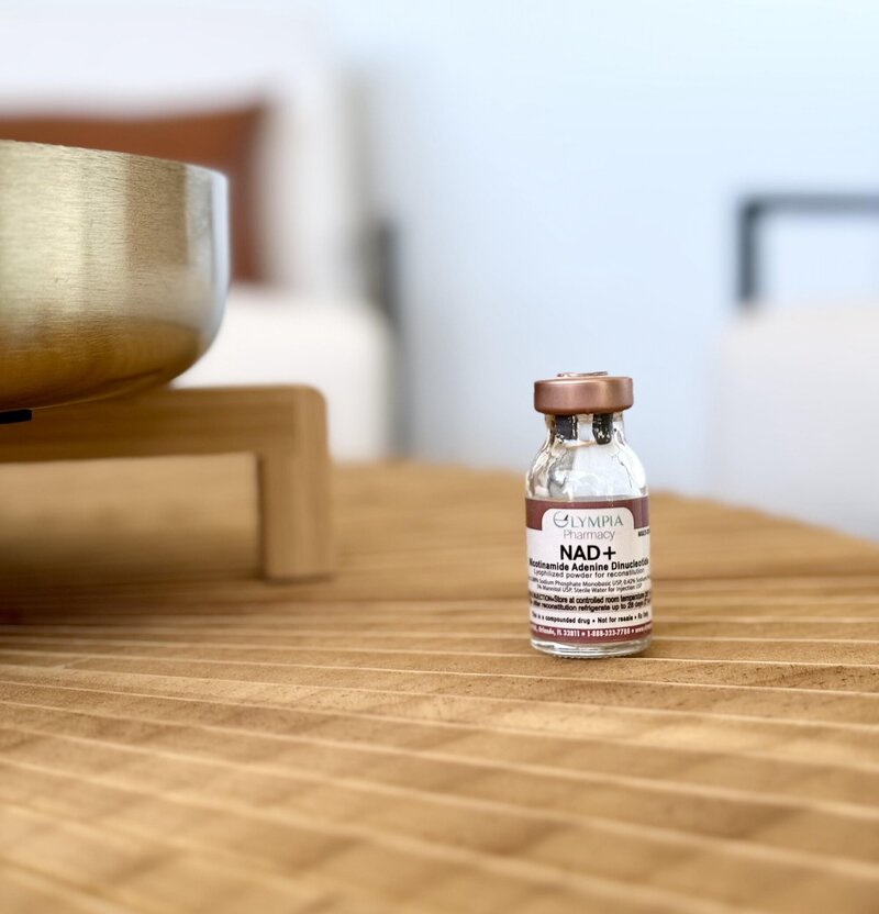Clear vile with label "Nad+" on a wood table
