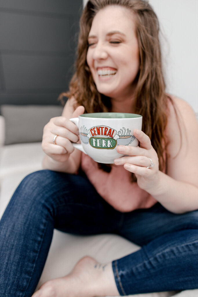 woman laughing holding friends central perk coffee cup