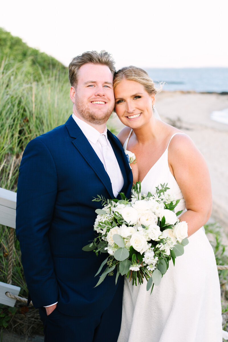 bride and groom smiling on the stairs during their pelham house resort cape cod wedding in