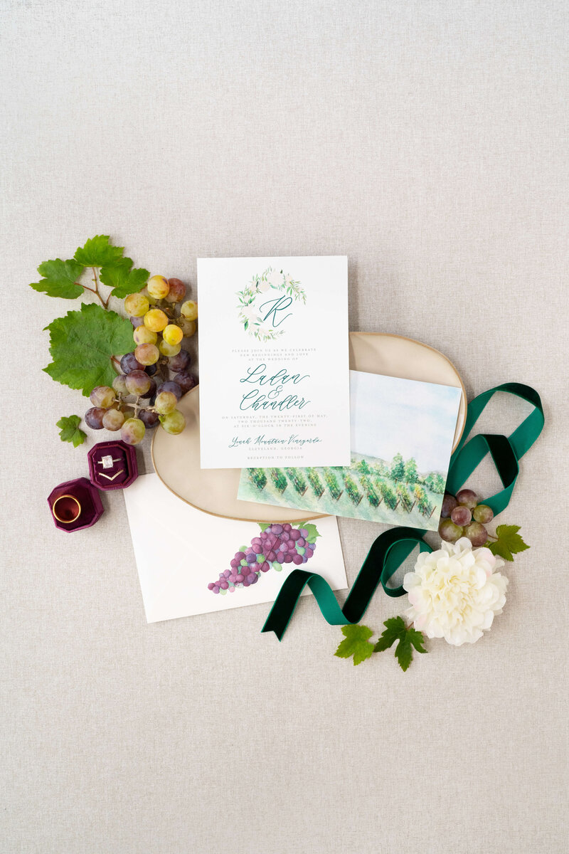 Winery wedding invitations for a North Georgia vineyard wedding, showcasing a custom wedding crest and a watercolor depiction of the vineyard