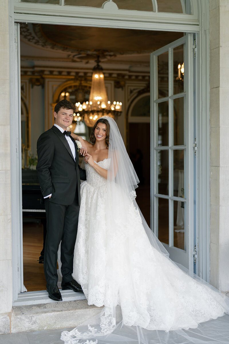 Kaitlyn and Chris in a doorway at Elkins Estate with a chandelier behind them