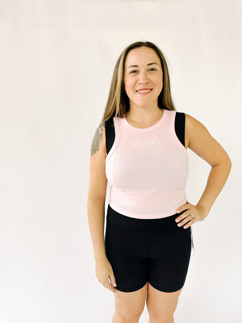 back of woman wearing pink tank with cream true40 logo