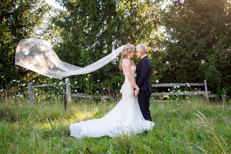 A same-sex couple posing on their wedding day at Bellamere Winery