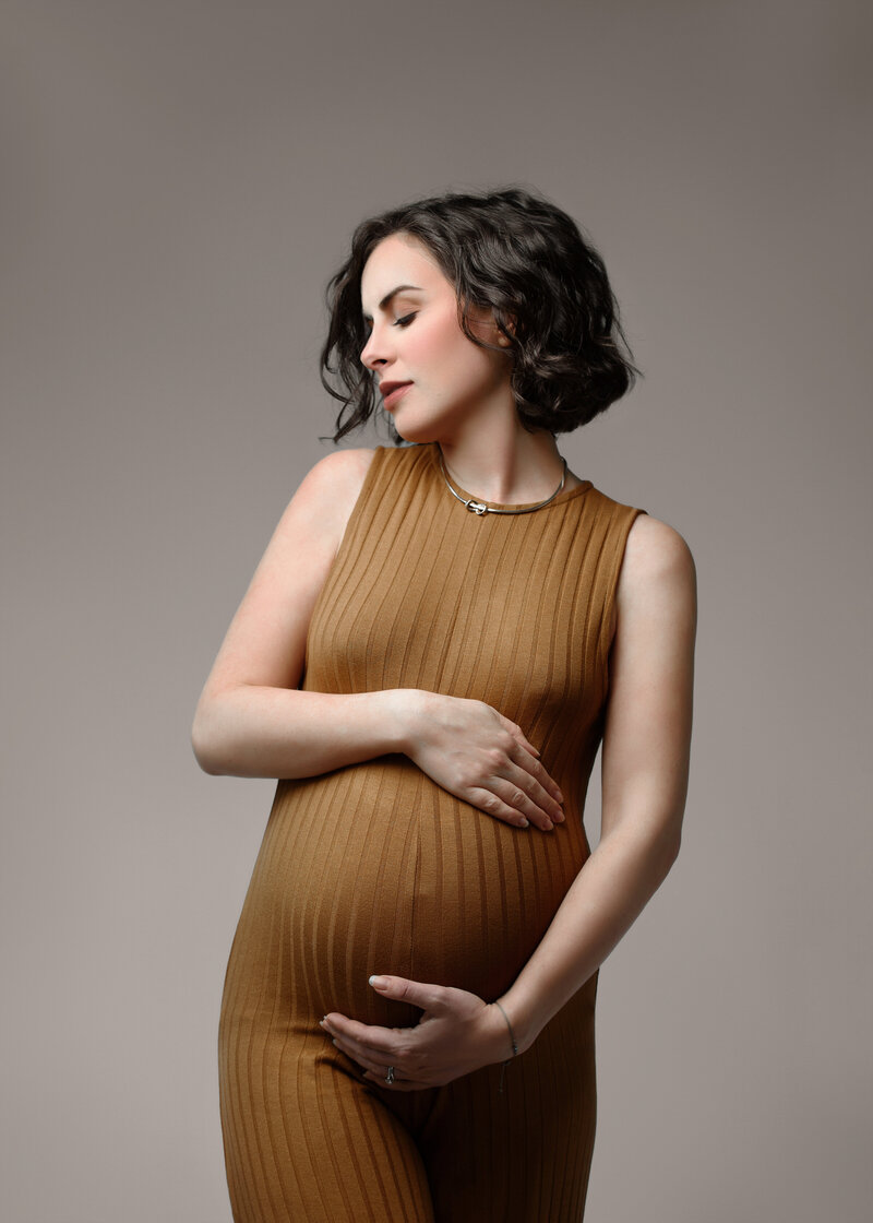 emotional mom to be hugging baby bump belly  in a timeless and classic way